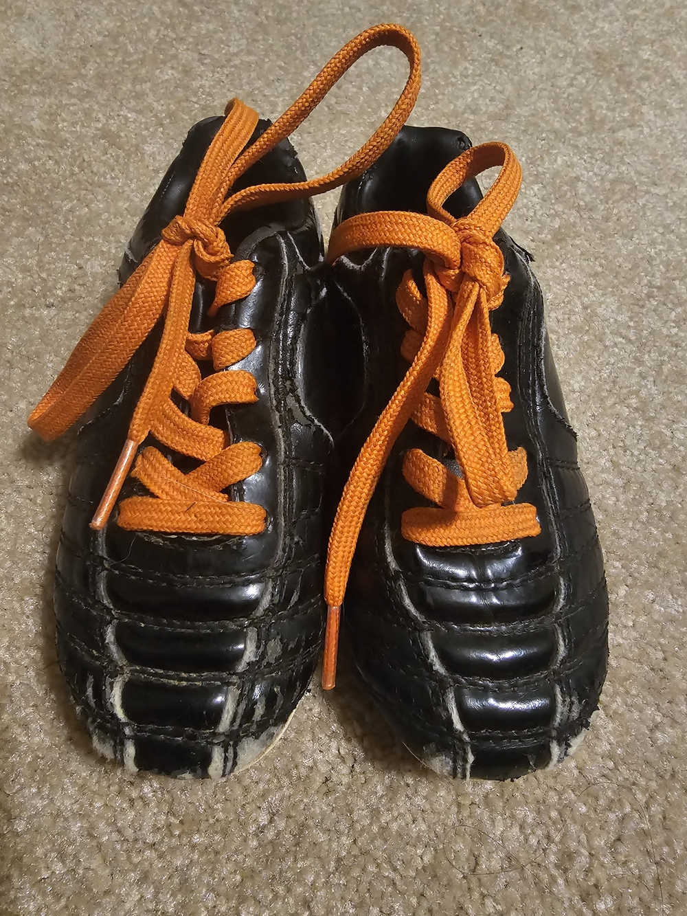 Kids Black Athletic Cleats with Orange Laces